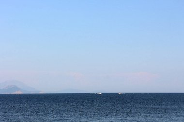 Mavi deniz ve kıyı sisli.