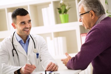 Onun üst düzey hasta dikkatle dinlerken başarı doktor gülümseyen