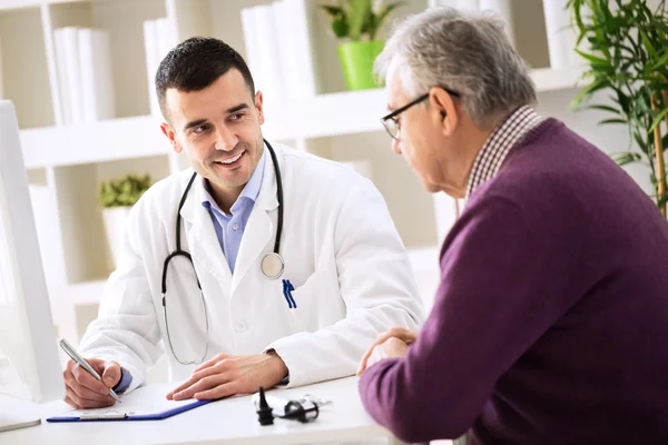 Arzt erklärt älteren Patienten Rezept — Stockfoto