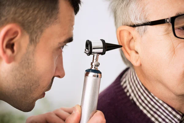 Médecin examinant l'oreille d'un patient — Photo