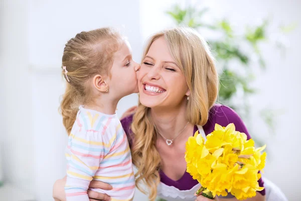 Datter som gir blomster og kysser glade mohter – stockfoto