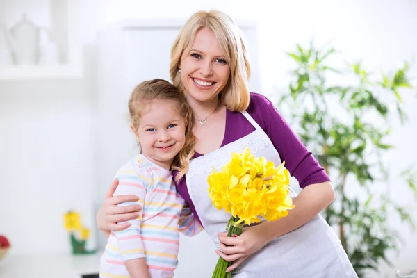 Ребенок и мать в объятиях с цветами — стоковое фото