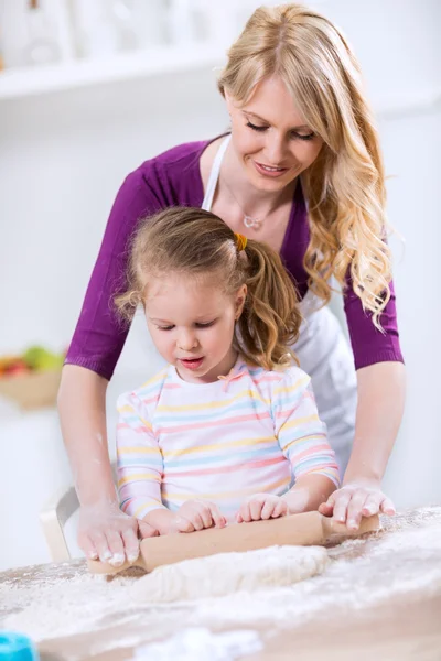 Mamma lär dotter att använda en brödkavel — Stockfoto