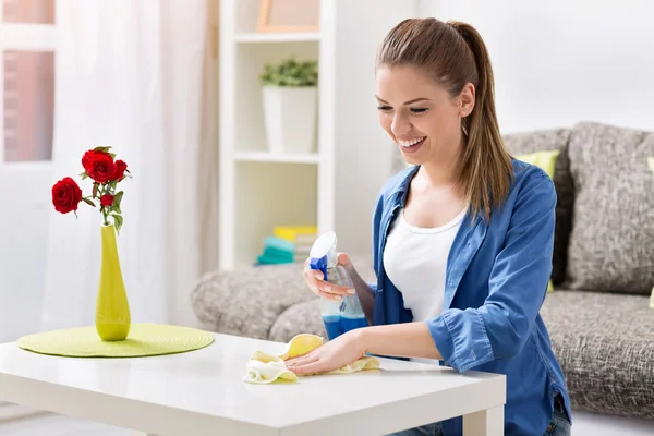 Mujer sonriente limpiando la mesa —  Fotos de Stock