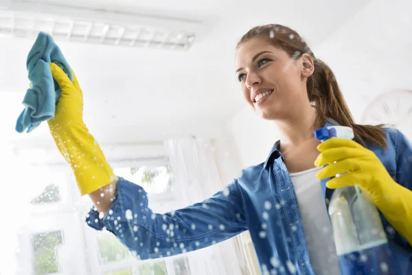 Lächelnde Ehefrau wusch das Fenster mit einem Tuch — Stockfoto