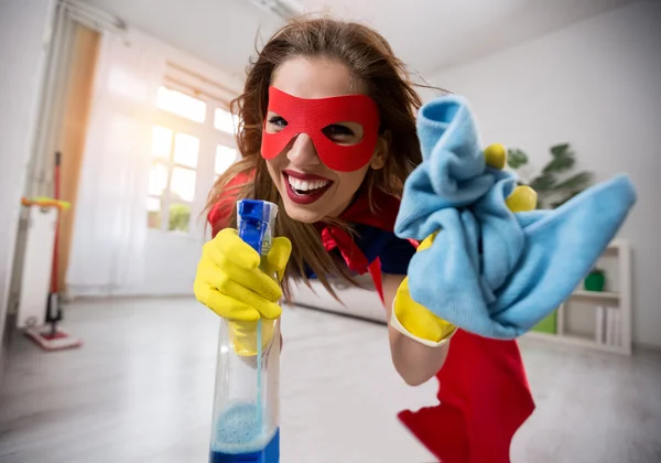 Woman superhero flying through the room with a mop — Stock Photo, Image