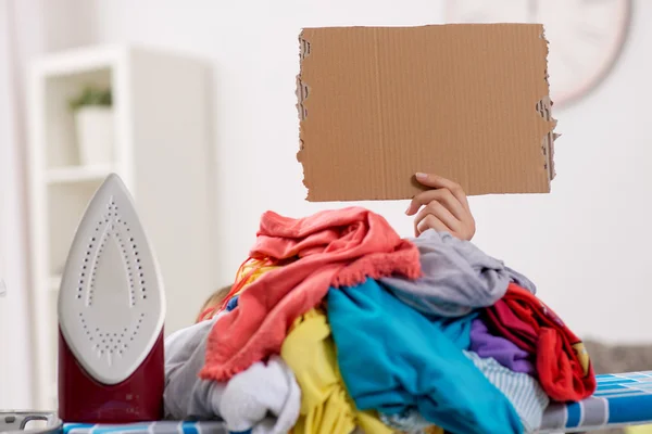 Fer à repasser femme, caché par une grande pile de linge — Photo