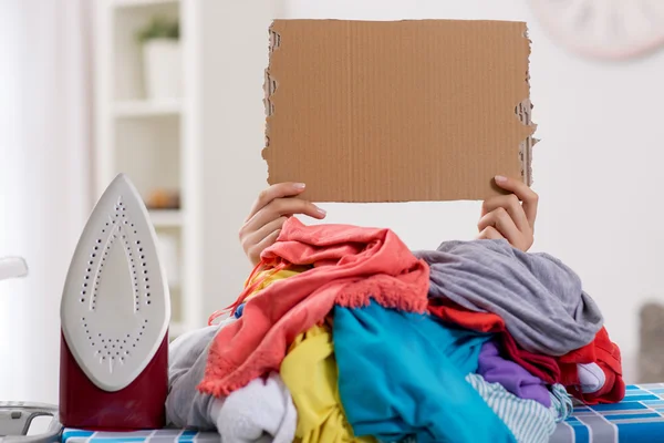 Žena, žehlení, skryté ve velké hromady prádla — Stock fotografie