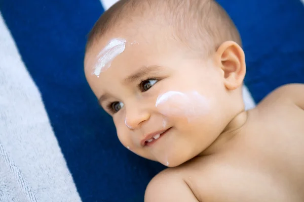 Menino com loção solar no rosto — Fotografia de Stock