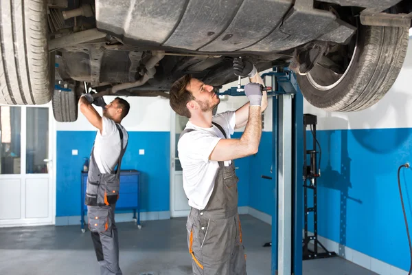 Mecánica trabajando juntos, coche de reparación de trabajo en equipo — Foto de Stock