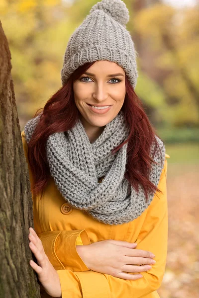 Mulher sorridente com um cachecol e boné cinza — Fotografia de Stock