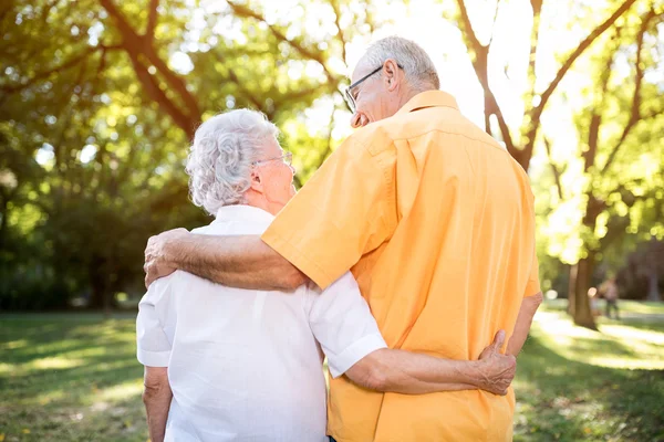 Lyckliga senior paret kramas i park — Stockfoto
