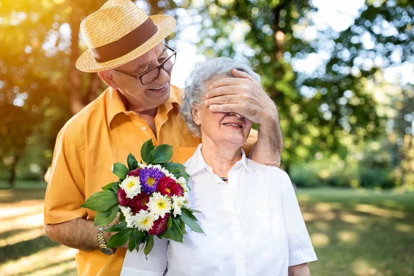 Senior homme donnant bouquet de fleurs colorées à sa femme — Photo