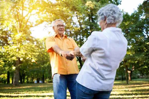 Старшая пара веселится и танцует в парке — стоковое фото