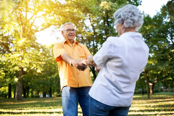 Pareja mayor divirtiéndose y bailando en el parque — Foto de Stock