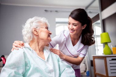 Dostça sohbet eden bayanlar, çalışkan hemşire ve kıdemli hasta, doktor hasta konsepti.