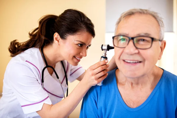 Dokter Menggunakan Otoskop Untuk Memeriksa Telinga Mans Tua Merawat Rumah — Stok Foto