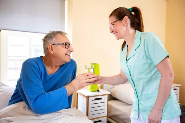 Loving Nurse Handing Glass Water Her Nursing Occupant Elder Peoples — Stock Photo, Image