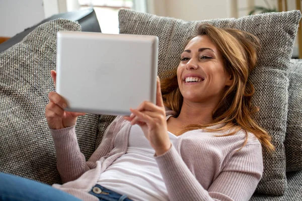 Happy Brunette Wanita Berbaring Sofa Dan Memegang Tablet Konsep Menyenangkan — Stok Foto
