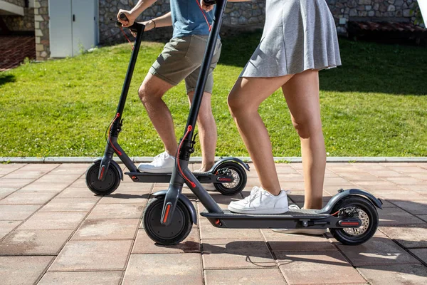 家の近くで新しい電動キックスクーターを試している2人の若者 楽しさと乗り心地の概念 — ストック写真