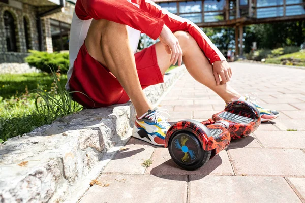 Young Man Sitting Side Block Pawed Road Next His Hoverboard — Stock Photo, Image