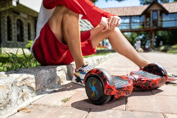 Joven Sentado Lado Calle Con Patas Lado Hoverboard Probando Nuevo —  Fotos de Stock