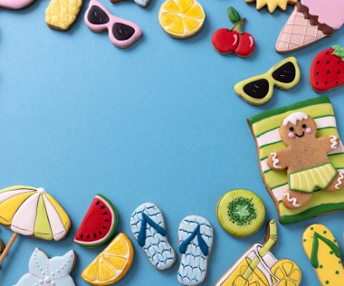 Mavi arka planda lezzetli tatlarla süslenmiş tropik yaz cennet temalı kurabiyeler, tatil konsepti