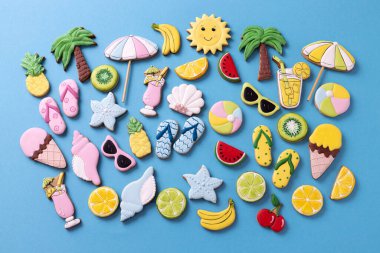 Mavi arka planda lezzetli tatlarla süslenmiş tropik yaz cennet temalı kurabiyeler, tatil konsepti
