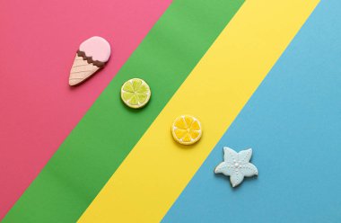 Renkli arka planda yaz ve plaj motifleri olan lezzetli kurabiyeler, tatlı kurabiyeler.