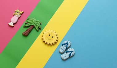 Çeşitli şekillerde lezzetli kurabiyeler, kokteyl, güneş, palmiye ağacı ve tanga terlikleri, yaz eğlencesi sembolik konsepti