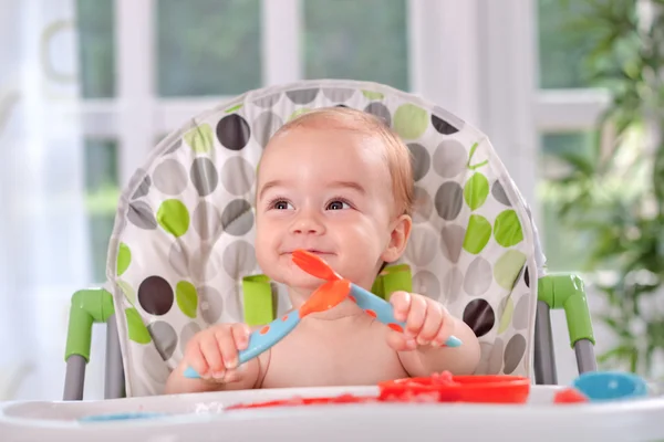 Bebê segurando-se com uma colher e garfo — Fotografia de Stock