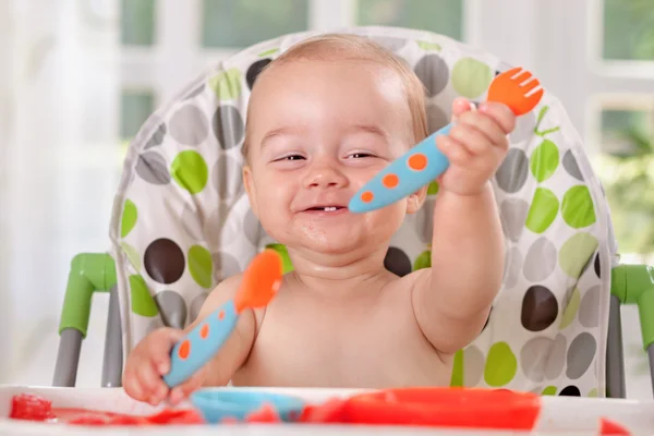 Feliz sonriente lindo bebé sosteniendo cuchara y tenedor — Foto de Stock