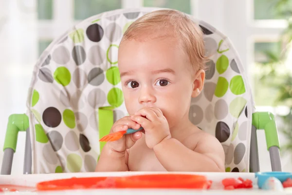 Bayi memegang garpu dan makan buah — Stok Foto