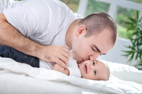 Vackra unga far att ge en kyss hans pojke — Stockfoto