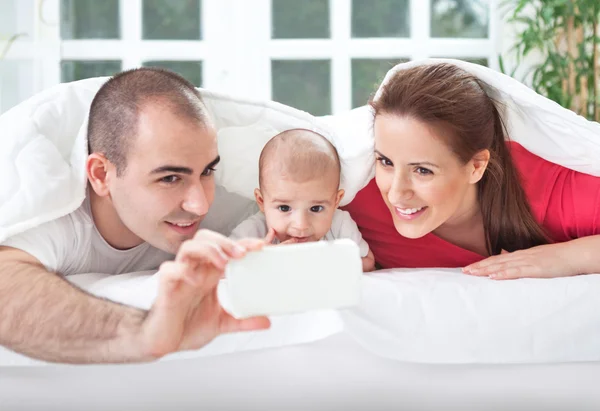 Happy famille souriante prendre des photos d'eux-mêmes — Photo