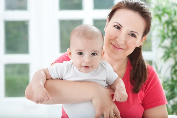 Bonita sorridente jovem mãe com seu bebê — Fotografia de Stock