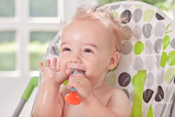 Smiling cute baby holding spoon and eating watermelon — Stock Photo, Image
