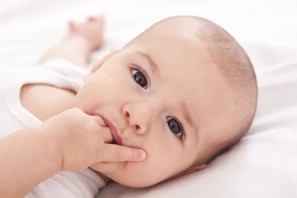 Pequeño bebé lindo poniendo los dedos en la boca — Foto de Stock