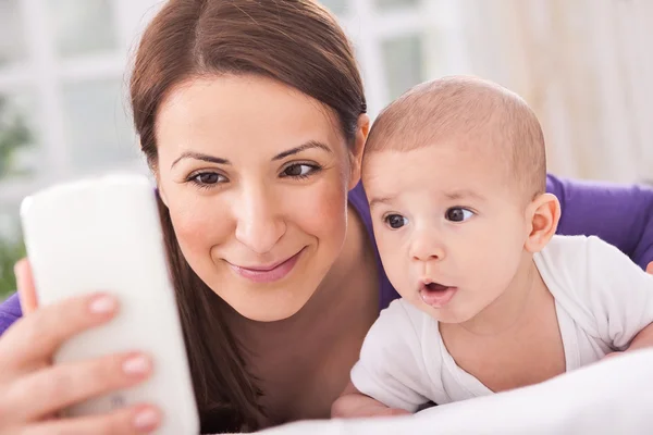 Anne ve babasıyla telefonda konuşurken bebek