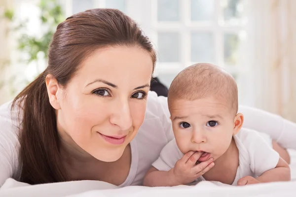 Glada leende familj njuta på sängen — Stockfoto