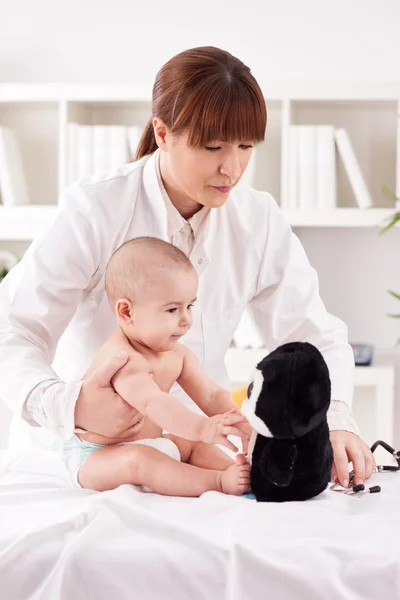 Female doctor pediatrician playing with patient baby — Stock Photo, Image