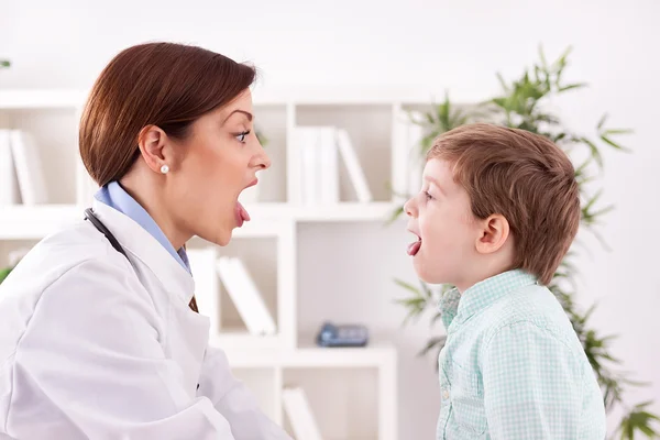 Paziente del bambino con il medico che mostra linguetta, gola di esame — Foto Stock