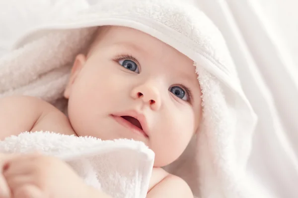 Bebé con ojos blus bajo la toalla blanca — Foto de Stock