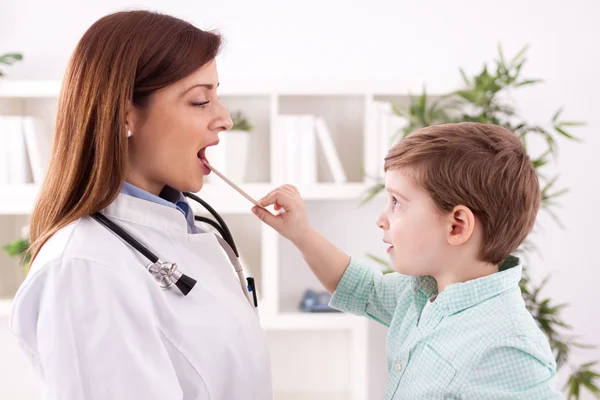 Niño pequeño jugando con el médico examinando —  Fotos de Stock