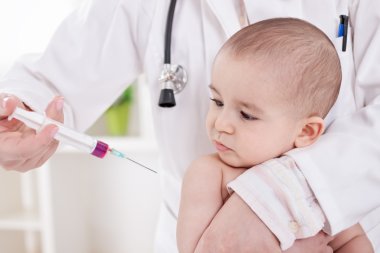 Female doctor doing vaccine to little baby boy clipart