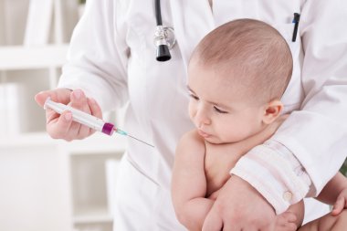 Bir çocuk bir aşı veren doktor