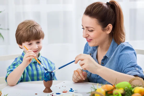 Beautiful mother teach son how to paint easter eggs — Stock Photo, Image