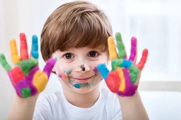 Schattige kleine jongen met gekleurde handen — Stockfoto