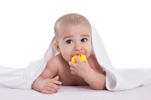 Adorable bebé sosteniendo y muerde pato amarillo después de la ducha — Foto de Stock