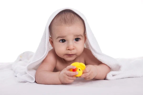 Cute baby enjoy under white towel with bath toys, isolated — Stock Photo, Image